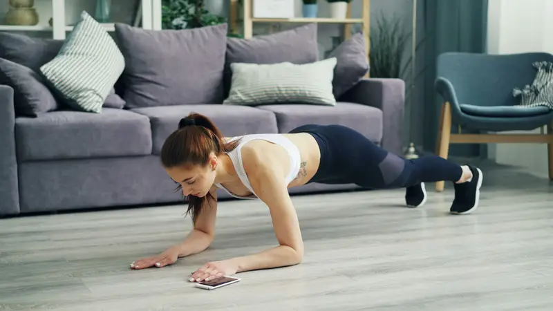 A woman doing push-ups on the floor at home