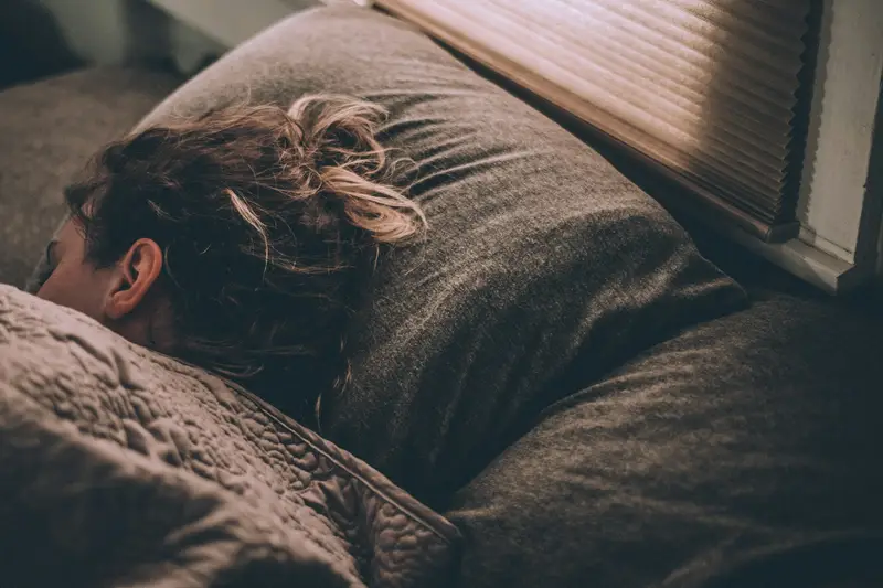 A woman sleeping peacefully under blankets